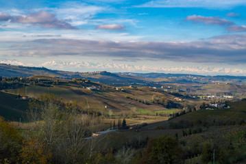 Langhe monferrato region autumnal hills and vineyards with mountains on background in Piedmont, Northern Italy.