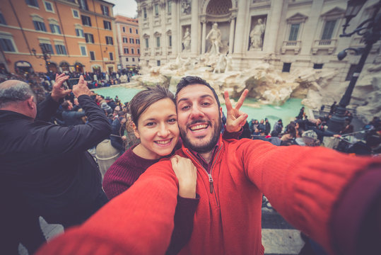 tourism in Rome, handsome couple smiling in the Trevi Fountain in Rome, Italy