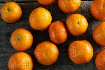 A lot of tangerines on a wooden background.