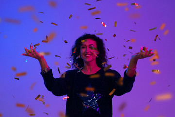 Portrait of beautiful woman playing with confetti . Celebration, Birthday, Christmas, New Year.