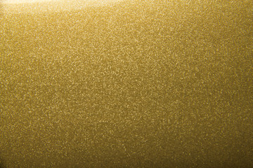 Shiny bright golden background with glitter closeup