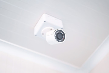 CCTV camera on white ceiling.