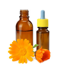 bottle with marigold oil with marigold flowers isolated on white background. calendula flower.