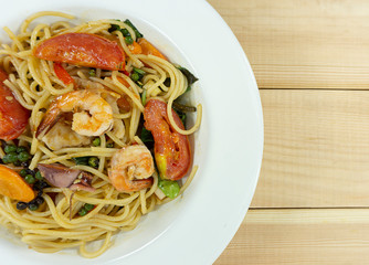 Spaghetti seafood in a dish on a white wood floor table, Top view with copy space for your text...