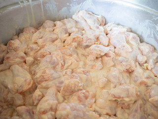 Raw chicken leg with all purpose flour in dish.