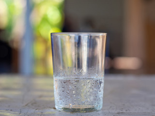 A glass of cold water on blurred background.