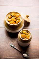 Homemade Gooseberry or amla Pickle/ or Aavle ka Achar in a bowl or barni over moody background.  selective focus