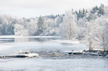 River in winter and tree covered with white frost.