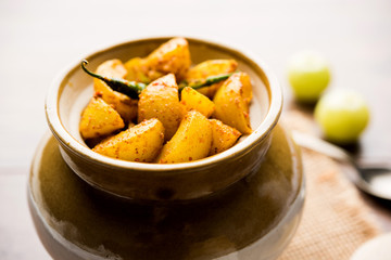 Homemade Gooseberry or amla Pickle/ or Aavle ka Achar in a bowl or barni over moody background.  selective focus