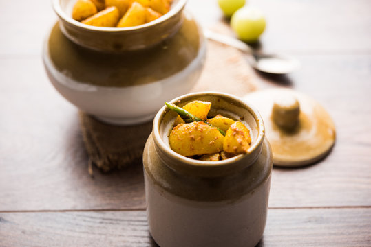 Homemade Gooseberry or amla Pickle/ or Aavle ka Achar in a bowl or barni over moody background.  selective focus