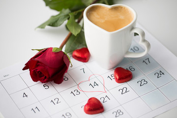 valentines day and holidays concept - close up of calendar sheet with 14th february date, heart...