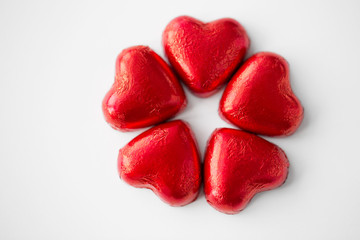 valentines day, sweets and confectionery concept - close up of red heart shaped chocolate candies...