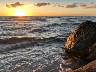 sunset over the sea, sun reflecting on rock