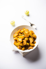 Homemade Gooseberry or amla Pickle/ or Aavle ka Achar in a bowl or barni over moody background.  selective focus