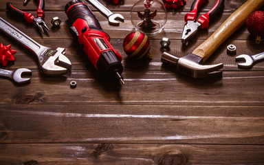 Merry Christmas and Happy New Years Handy Constrcution Tools background concept.  Handy House Fix DIY handy tools with Christmas ornament decoration on a rustic wooden table.
