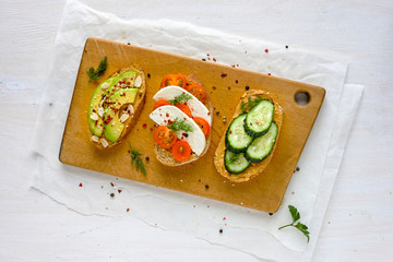Set of sandwiches served on wooden board