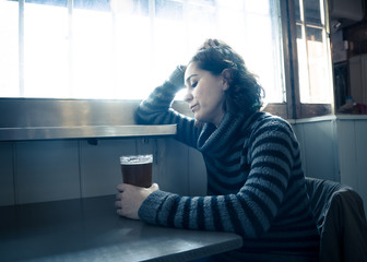Alcoholic depressed woman drinking in a bar feeling sad hopeless