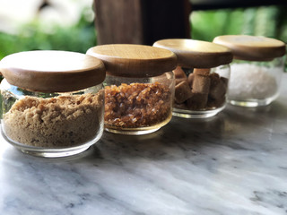kind of sugar on the glass jar  Wooden cap put on white marble table with natural light
