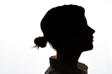 Dark silhouette of a young girl on a white background, the concept of anonymity