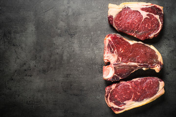 Dry aged beef steaks - ribeye, striploin, t-bone steaks on Black