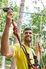 Lächelnder junger Mann im Hochseilgarten