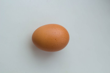 Single brown egg isolated from white background.
