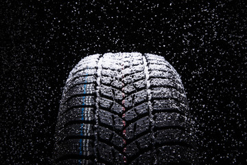Winter Car tires with snow on black background - obrazy, fototapety, plakaty