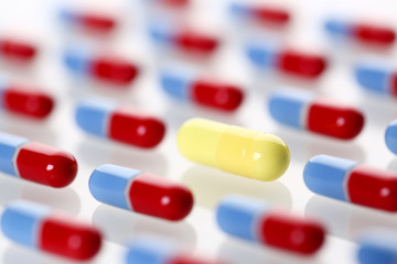 One special yellow pill stand out from pile of identical red and blue fellows