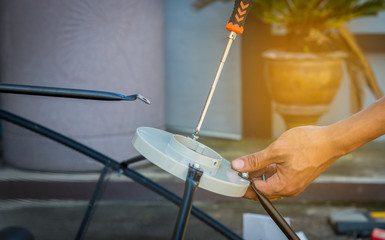 Technician assembling Satellite system by screwdriver for installation.