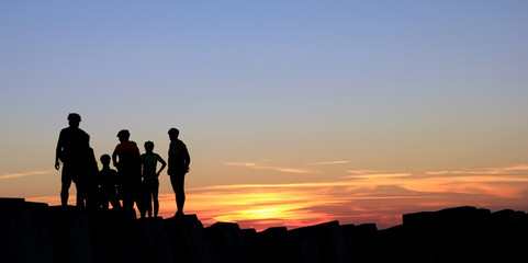 Fototapeta premium Team of bikers meeting sunset on Figueira da Foz Molhe Sul lighthouse, the Atlantic Ocean, Portugal