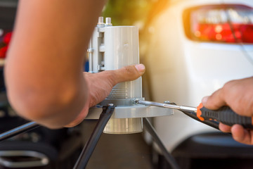 Technician assembling Satellite system by screwdriver for installation.