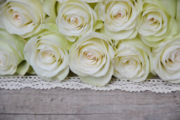 Obraz na płótnie Canvas White roses on wooden background