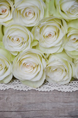 White roses on wooden background