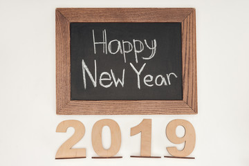 top view of 'happy new year' text on chalk board with 2019 date made of plywood isolated on white