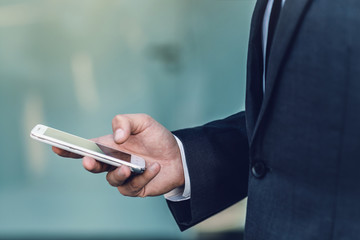 Businessman in a suit using a smartphone. Search and concept of social networks.