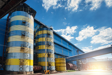 Industrial water tanks silo. Outdoor steel bulk storage tanks with blue sky view background. The storage of water for raw materials in industry process and factory produce. - selective focus.