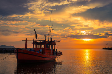 Fototapeta premium Silhouette fishing boat parking on beach at sunset time sky backgroun