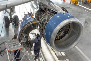 Technical specialists and aircraft technicians install the reverse engine after scheduled service. Concept maintenance of airplane.