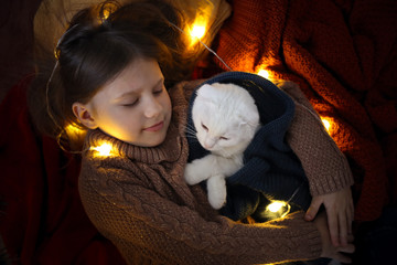 cat and kid sleeping together under Christmas tree
