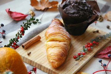 Chocolate Muffin and Croissant on Witner Themed Background