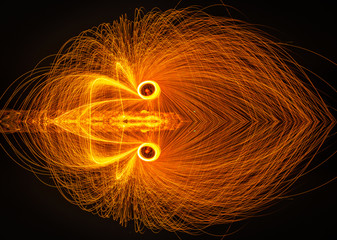 The beautiful fire dancer swing fire dancing show on the beach with dark clouds,dark sky background