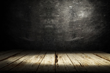 Dark wooden table with shadow and black wall background 