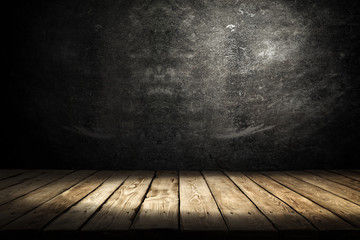 Dark wooden table with shadow and black wall background 