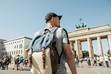 A tourist or a student with a backpack in Berlin in Germany visits the sights. Ahead is the...