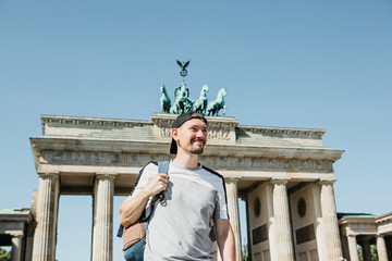 Portrait of a positive smiling tourist or student with a backpack in Berlin sightseeing in Berlin....