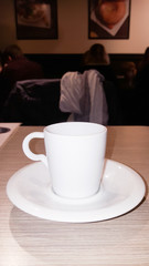 side view of white coffee cup in wooden table