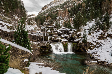 Cascada escalonada en un valle nevado