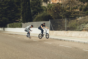 Extreme urban sports concept .Young people with bmx bicycles and skateboards on the street