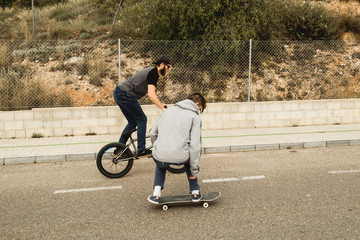 Extreme urban sports concept .Young people with bmx bicycles and skateboards on the street