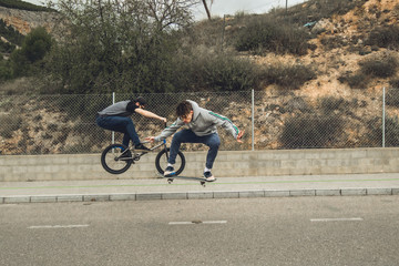 Extreme urban sports concept .Young people with bmx bicycles and skateboards on the street